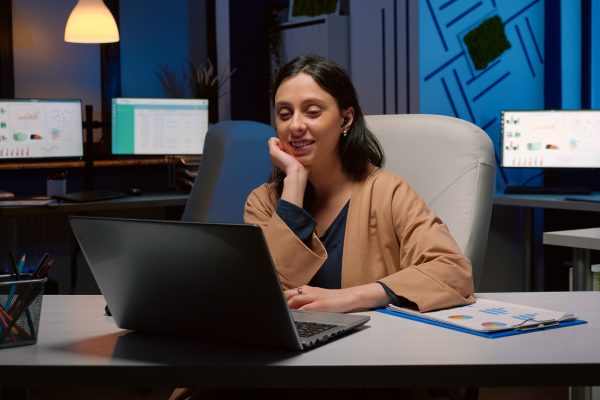 Businesswoman on business teammeeting conference videocall online greeting remotely collegues discussing management strategy late at night in startup office. Tired entrepreneur on internet web webinar